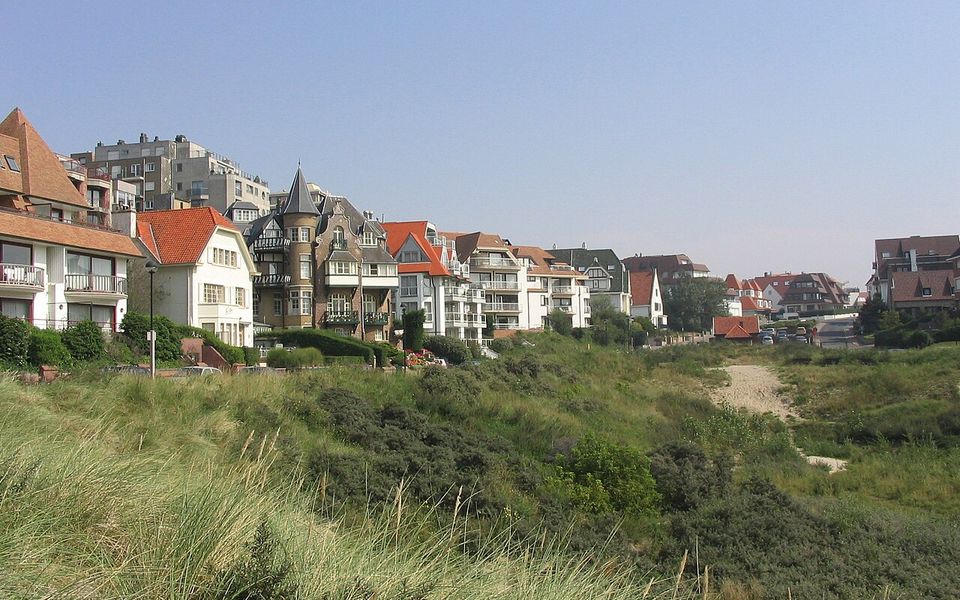 De elegante Lippenslaan in Knokke met luxe boetieks en een zonnige boulevardsfeer