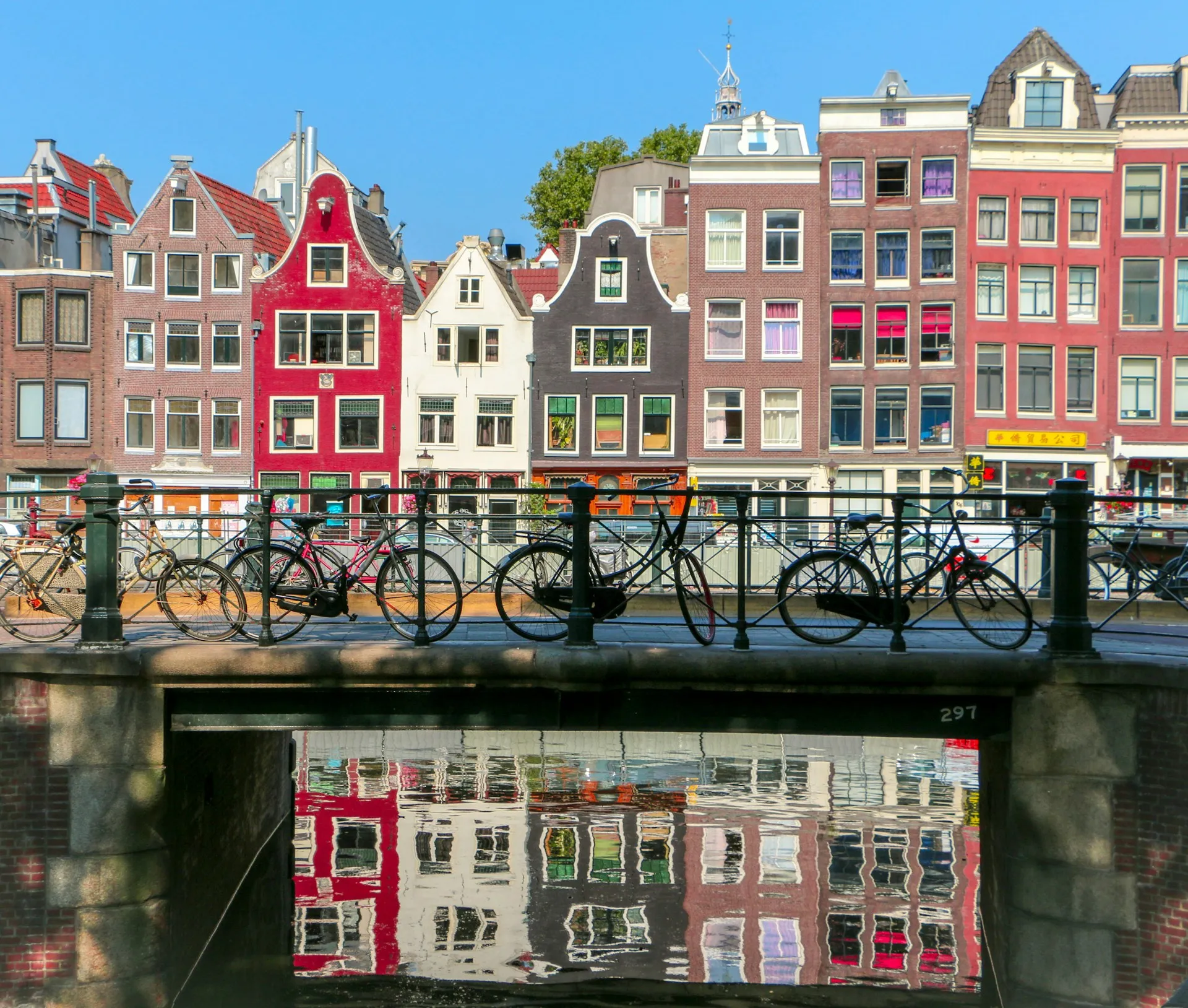 Kleurrijke grachtenpanden en fietsen langs een Amsterdamse gracht