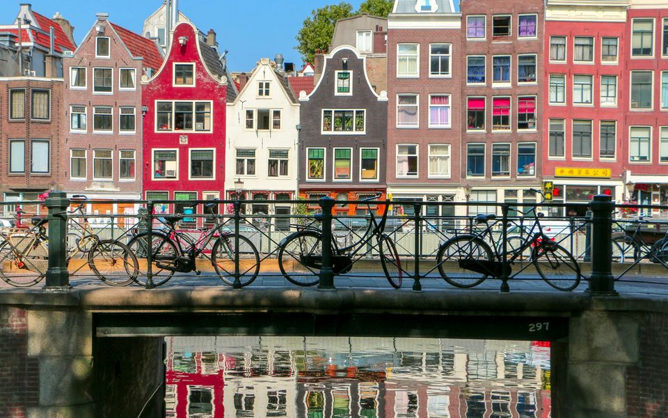 Kleurrijke grachtenpanden en fietsen langs een Amsterdamse gracht
