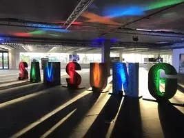 Lumière du soleil traversant une salle de réception avec la signalétique du logo Samsung