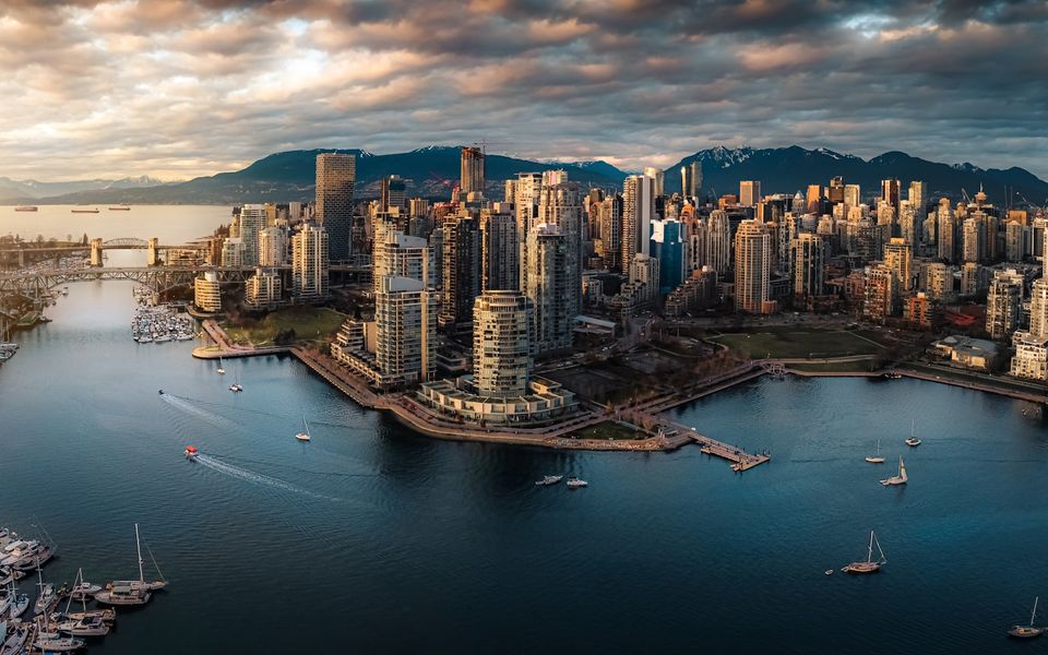 La presqu'île du centre-ville de Vancouver et False Creek au coucher du soleil, avec les montagnes de la rive nord