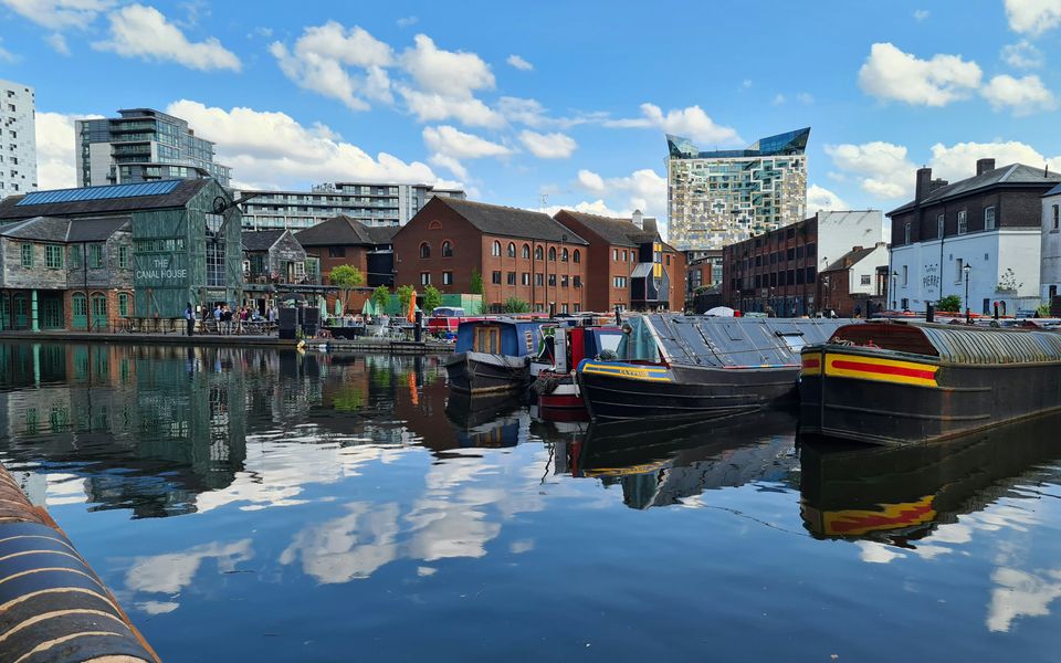 Birmingham canal boats and waterfront buildings on a sunny day
