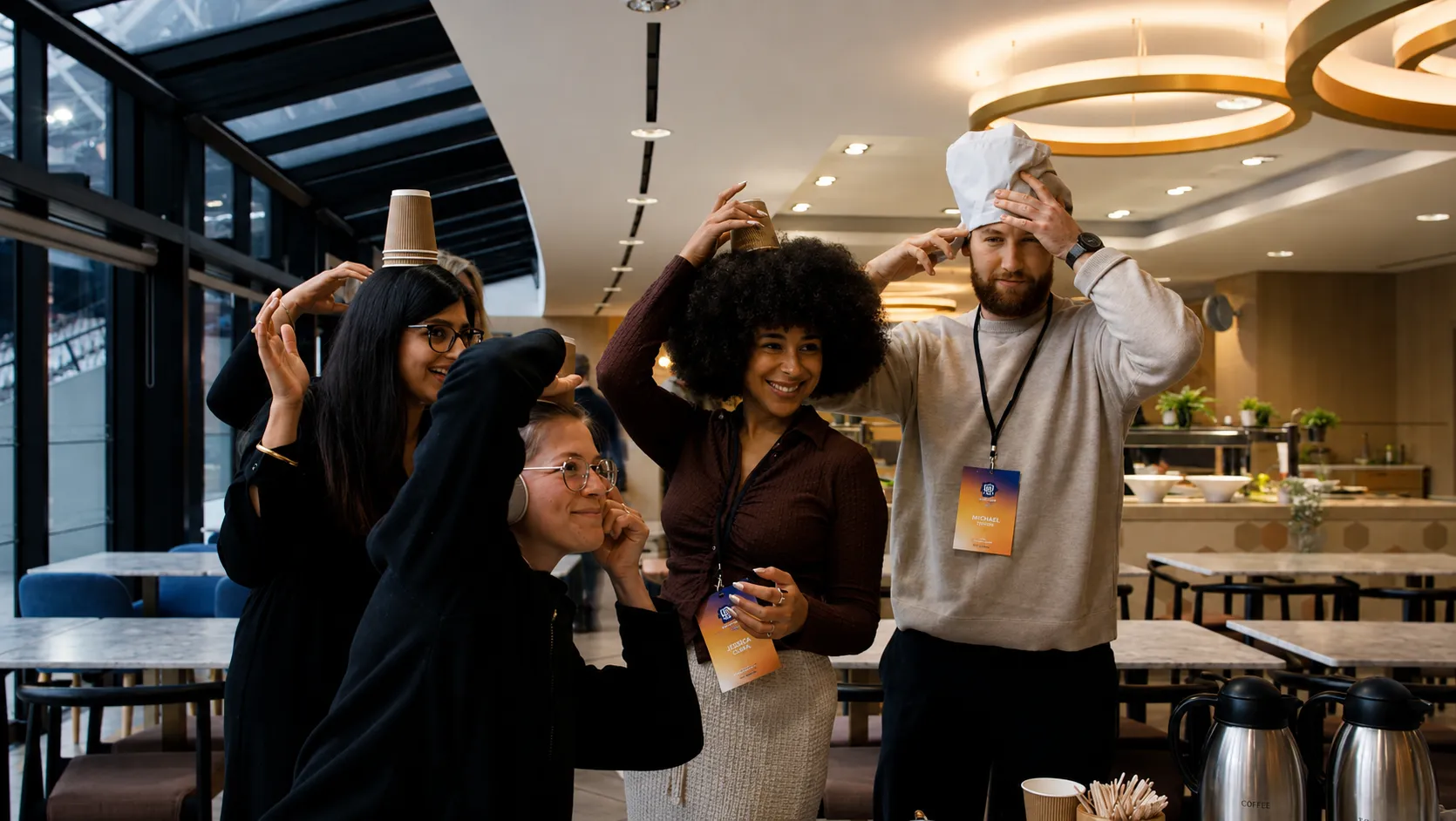 Employees participating in a playful office team building game, balancing objects on their heads in a collaborative indoor setting.