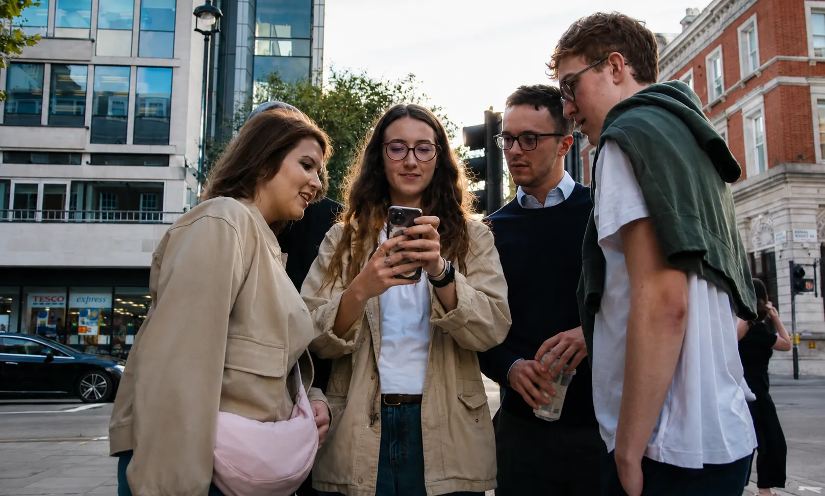Group of coworkers completing a mobile-based team building challenge in an urban city centre setting